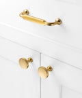 Premium Solid Metal Brushed Gold Cabinet Pulls on white drawers, heavy duty design with round knobs and sleek finish.