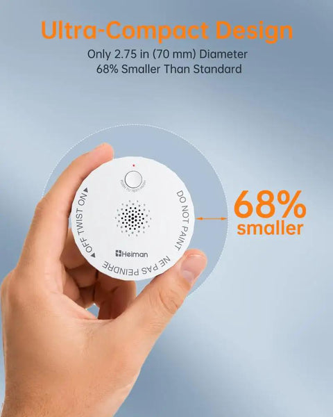 Hand holding ultra compact wireless smoke detector, measuring 2.75 inches, featuring ten year battery life and seamless RF linked alerts.