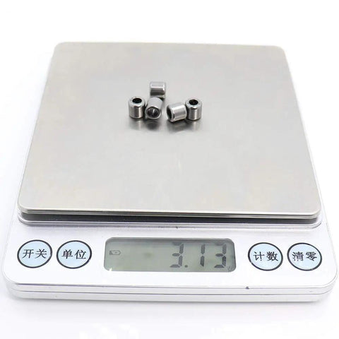 SCE24 Drawn Cup Needle Roller Bearing 3.175X6.35X6.35mm on a scale weighing 3.13 grams, showcasing high precision.