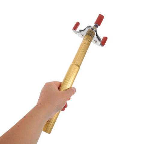 Hand holding the Kick The Ladder Aside With This No Sweat Smoke Detector Removal Tool Featuring A Smooth Aluminum Claw.