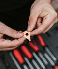 Hands holding part of Durable Dent Pulling Rings for Auto Body and Sheet Metal Repair Kit in front of tool set