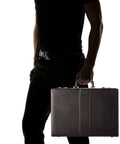 Silhouette of man holding Premium Black Expanding Document Portfolio With Secure Combination Lock And Roomy File Compartments.