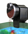 Slick Install Automatic Fish Feeder For Aquarium Battery Operated dispensing pellets, mounted on tank rim with adjustable portion control.
