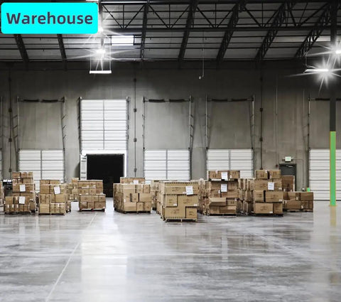 Warehouse interior with stacked boxes and high ceilings, featuring loading doors and bright overhead lights.