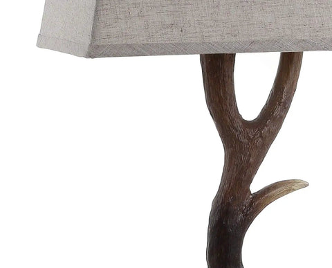 Close-up of rustic 29.5 inch antler table lamp with light grey linen shade on faux resin base for cabin decor.
