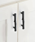 Heavy Duty Black Tree Branch Cabinet Pulls on white kitchen cabinets, showcasing rustic twig design and durable zinc alloy material.