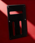 Guitar Back Panel Replacement Part For Electric Guitars, Lightweight precision fit, black sleek finish backplate on red background