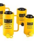 Four yellow industrial hydraulic lifting jacks with labels, varying capacities, and strokes, showing handles and connectors.