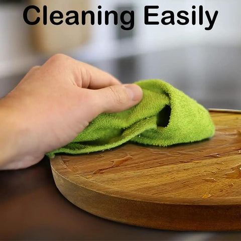 Hand wiping the Smooth As Butter 14 Inch Solid Acacia Wood Lazy Susan Rotating Turntable for easy cleaning.