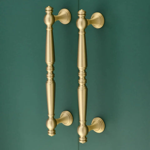 Heavy Duty Five Inch Solid Brass Cabinet Pulls In Brushed Matte Gold for kitchen cabinetry and bathroom vanities on green background.