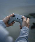 Hands holding the FPV Remote Controller 3 for O4 video transmission, featuring lightweight design and extended sticks for precise control.