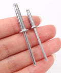 Close-up of hand holding Aluminum Alloy Blind Rivets Kit 200 Pcs M4 with round head tri-fold design for metal DIY projects.