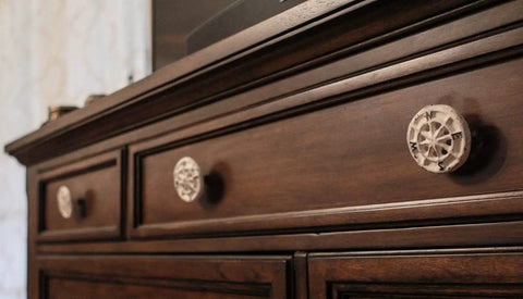 Rock Solid Compass Rose Drawer Pulls Set Of 12 In Antique White Cast Iron Nautical Cabinet Handles on a dark wood dresser