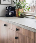 5 Pack Black Round Cabinet Knobs With Kickass Matte Finish And Heavy Duty Zinc Alloy Build Hella Durable For Kitchen Drawers And Dresser Doors Includes Mounting Hardware on wooden cabinet in modern kitchen.