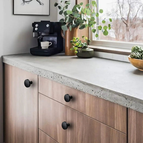 5 Pack Black Round Cabinet Knobs With Kickass Matte Finish And Heavy Duty Zinc Alloy Build Hella Durable For Kitchen Drawers And Dresser Doors Includes Mounting Hardware on wooden cabinet in modern kitchen.