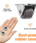 Close-up of Mini Half Inch Fixed Casters With Metal Top Plate, 16 Pack, shown with hand for scale, dust-proof rubber cover visible.