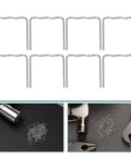 A set of silver hot melt staples from the Tough as Nails Plastic Welding Rods and Hot Melt Staples Kit on a black surface.