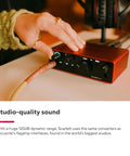Hand adjusting Scarlett Solo Studio 4th Gen USB Audio Interface Bundle with dials and cables for recording, close-up view.