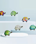 Tiffany Style Turtle Lamp Stained Glass Desk Light Green Turtle 8x5x4 Inch With Bronze Base UL Listed Push Button Switch Easy Assemble 3W 2700K LED Bulb Compatible colorful stained glass turtle lamps on display stands.