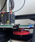 Close-up of 3D printer heat bed with Silicone Bed Mounts And Spacers Kit for precise leveling, featuring red adjustment wheel.