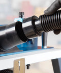 Close-up of heavy-duty dust collection kit attachment on Rock Solid Benchtop Router Table Setup with adjustable aluminum fence.
