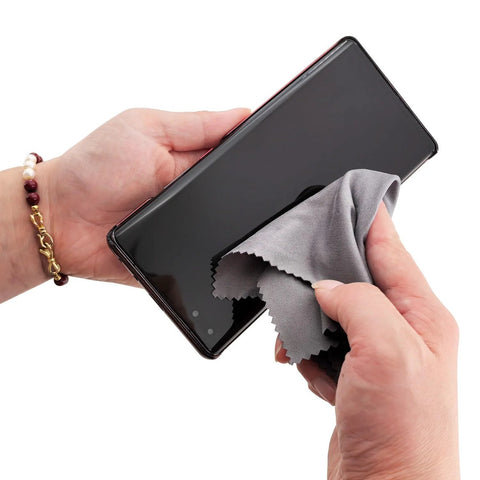 Xthel microfiber cleaning cloth; close-up of hand wiping smartphone screen with gray cloth