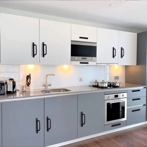 Modern kitchen with matte black cabinet handles on white and gray cabinets, showcasing 12 Pack Matte Black Cabinet Handles Aluminum Drawer Pulls.