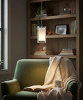 Cozy room with Dual Glass Pendant Lights 2 Pack With Brushed Nickel Finish Adjustable, illuminating an armchair with books.