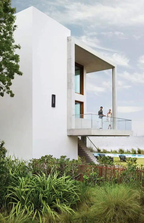Modern house with sleek architecture and balcony, showcasing Three Light Extra Large Outdoor Wall Lantern With Slick Titanium Finish And GU10 Socket Built From Solid Aluminum For Dark Sky Compliant Lighting That Delivers A Badass Urban Vibe And Heavy Duty Performance.