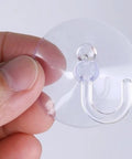 Super Strong Suction Cup Hooks For Bathroom Wall 10 Pack held in hand showing clear resin design for easy hanging.