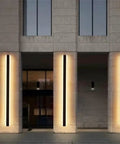 Sleek Rectangular LED Wall Sconce Featuring Waterproof Aluminum Housing And COB Light Source on building pillars.