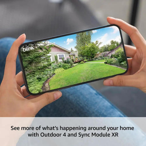 Set It And Forget It Wireless Outdoor Camera Pair With Long Range Sync Module And Weatherproof Hd Home Surveillance Kit Cranking Up The Security Game With Two Year Battery Life And One Year Plus Plan shown on a smartphone monitoring a landscaped yard.