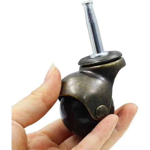 Antique Bronze Furniture Casters with No Sweat Rolling Action held in hand, showcasing the metal build and glossy ball roller.