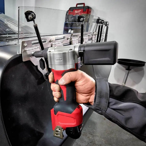 High-Torque M12 Cordless Rivet Gun Bare Tool Built to Rip Through Stainless Steel Rivets With Ease in use on a metal sheet.