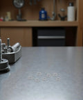 Tough As Nails Stainless Steel Spring Lock Washers M6 For Screws 300 Pack laid on a workbench, showcasing split ring design.