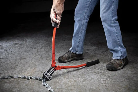 Using 24-Inch High Leverage Compound Bolt Cutter With Stabilizer Handles, Center-Cut Jaws on metal chain, demonstrating cutting power.