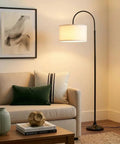 Nora Arc LED Tall Floor Lamp With Heavy Base For Living Room And Office next to sofa with modern decor