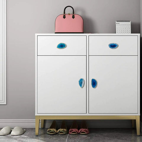 Four Piece Real Deal Agate Drawer Knobs With Gilded Brass Finish And Install Screws on a white cabinet.