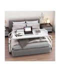 Smooth Operator Rolling Overbed Table With Heavy Duty Casters And Tilt Backboard For Zero Stress Laptop Days And Ultimate Breakfast In Bed Chill Zones On King Beds Today, set up over a bed with a laptop and books.