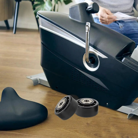 Universal Replacement Wheel Bearing Rollers For Treadmills And Exercise Bikes Heavy Duty Glide Casters lying near a black exercise bike.