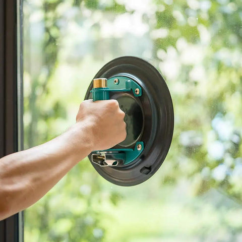 Hand gripping Heavy Duty 9 Inch Vacuum Concave Suction Cup for Granite and Glass Lifting on glass surface.