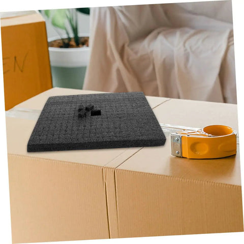 Black Foam Cube Inserts shockproof shipping filler on top of cardboard boxes, designed for void cushioning and protection.