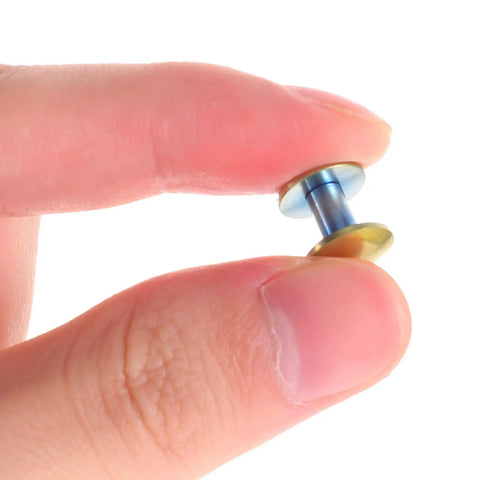 Close-up of Two Piece Titanium Alloy Binding Screws For Heavy Duty Document Sorting and Hella Durable Scrapbook Fasteners held in hand.