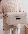 Heavy Duty Fabric Storage Bins With Snap On Lids Stackable Khaki Storage Boxes held by a person in a sweater.