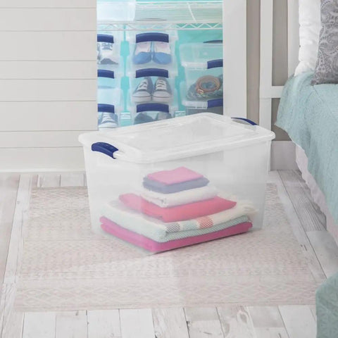 Six Pack Of 66 Quart Clear Plastic Storage Containers With Sleek Blue Latching Lids Designed For Heavy Duty Stackable Organization And Hassle Free Clutter Control In Your Living Room Or Home Office, filled with folded blankets.