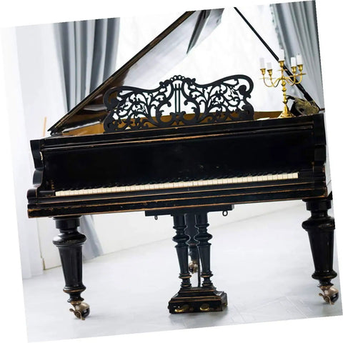 Antique black grand piano with ornate lid, featuring elegant legs and wheels for easy mobility in a bright room.