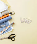 Top Shelf Universal Replacement Zipper Pull Heads 20 Piece Metal Kit With Sleek Detachable Tabs For Backpacks Purses Jackets And Luggage Repairs That Are Pure Gold on a table with sewing materials.