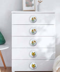 Kick Up Your Rustic Style With Eight Darn Cute Ceramic Kitchen Cabinet Drawer Knobs Featuring Pretty Sunflower And Butterfly Art For Dressers And Cupboards Designed For Smooth Grip Easy Install And Farmhouse Vibes on a white dresser.