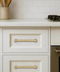 Top Shelf 10 Pack Brushed Brass Cabinet Pulls 5 Inch centered on white drawer in a modern kitchen setting.