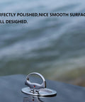 Rock Solid 316 Stainless Steel Marine Cam Hatch Latch with Smooth Flush Pull Handle resting on a polished surface by the water.